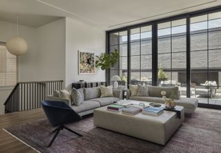 A colorful rug sits beneath a gray sofa and blue accent chair