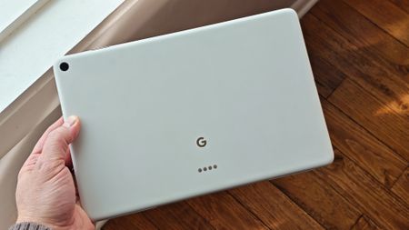 Holding a white Google Pixel Tablet and looking at the back