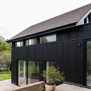exterior of a property with a large extension covered in black timber cladding