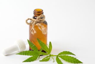 A bottle of cannabis oil, and leaves.