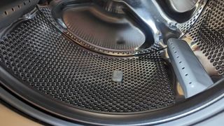 A dishwasher tablet in the drum of an empty washing machine