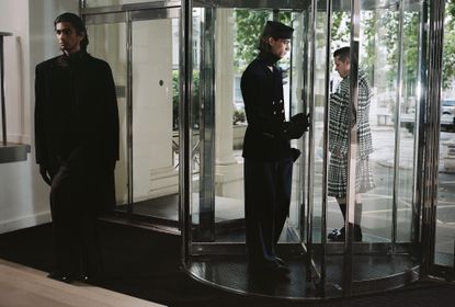 Three men in A/W 2022 menswear in revolving office door