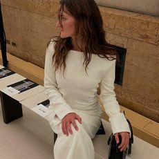 Eliza Huber wearing a white dress with black boots at the Tory Burch show in New York. 
