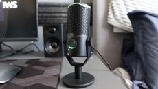 JBL Quantum Stream Studio microphone on a desk in front of a monitor
