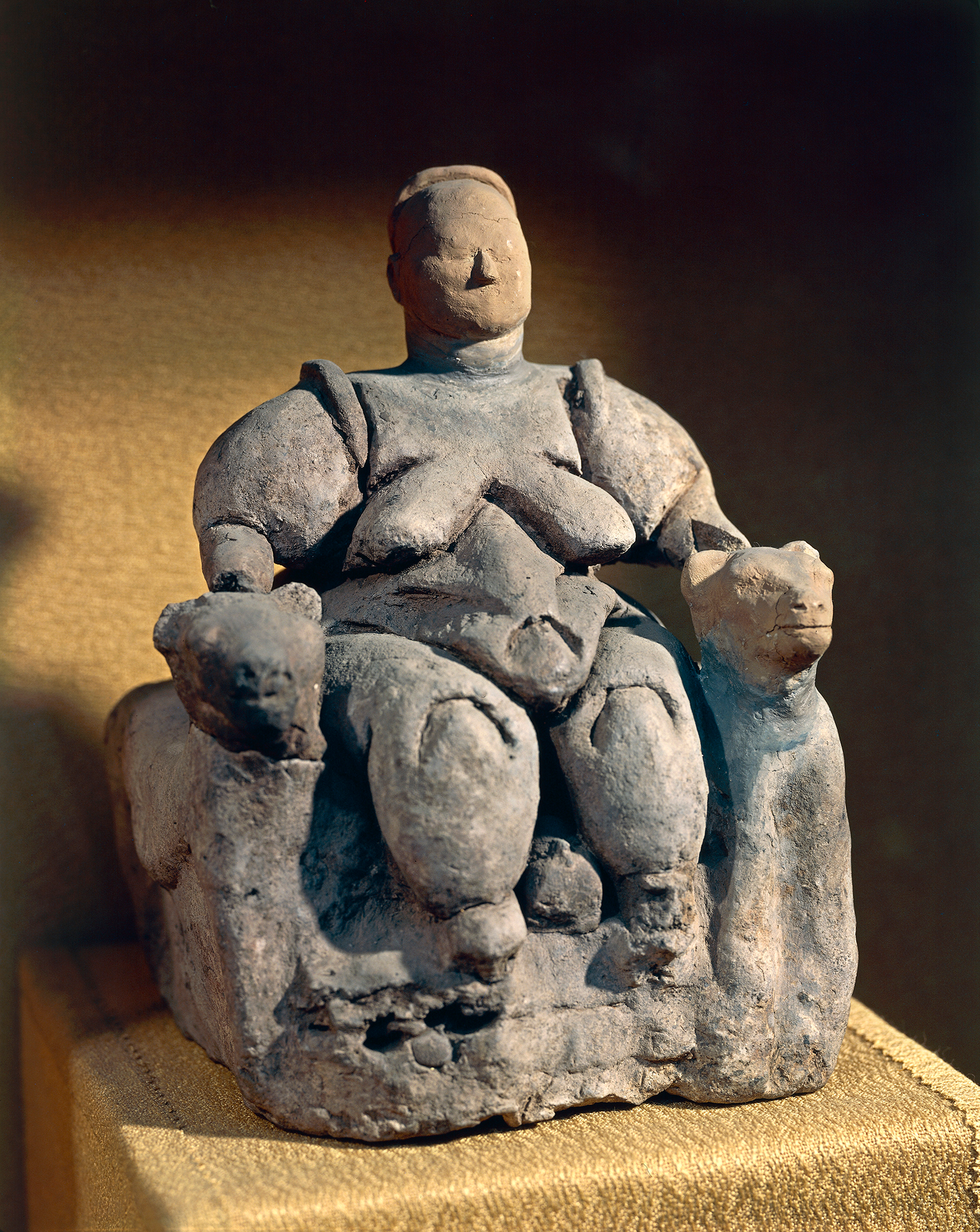 A close up of a female statue sitting on a chair