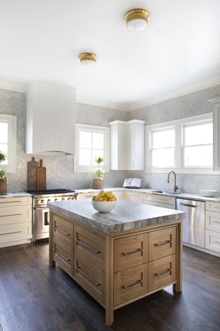 White kitchen with wooden island and flush gold lighting