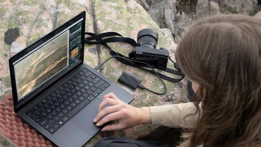Person using Samsung T9 SSD with laptop and photography tools