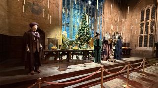 The head table with mannequins of characters in costumes in the dining hall set on the Harry Potter Studio Tour