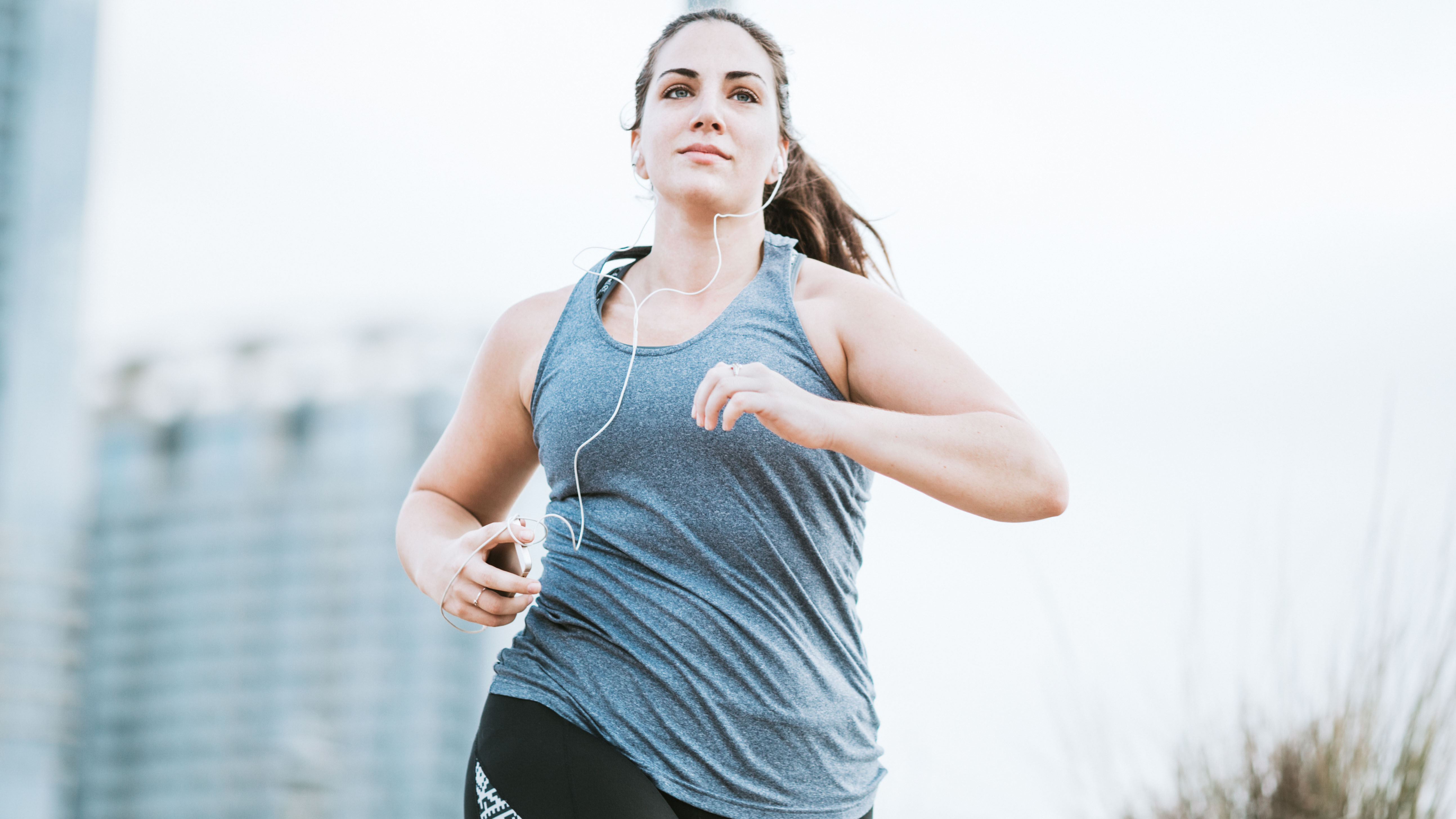 Mujer trotando en camiseta sin mangas gris