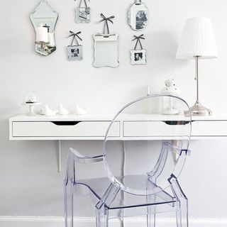 white wall with designed mirrors white desk white lamp and designed glass fiber chair