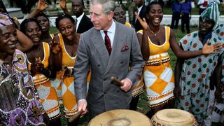 Prince Charles, the Prince of Wales plays drums with dancers of the Sierra Leone National Band Troupe as he arrives at the Golf Club on November 27, 2006 in Freetown, Sierra Leone. This is the first day of a four-day royal tour to Sierra Leone and Nigeria.