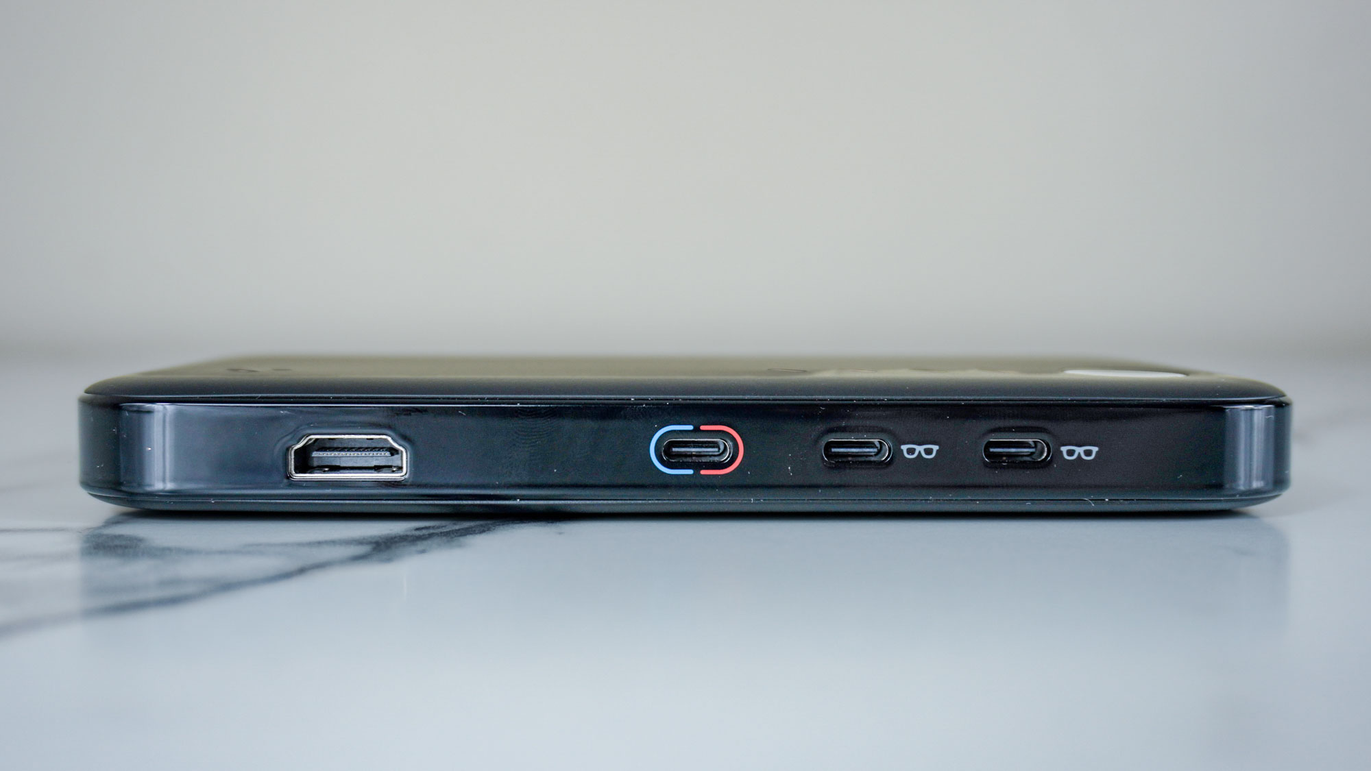 The Viture Pro Mobile Dock on its side showing off its HDMI port and three USB-C ports