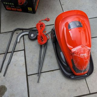 Flymo Easiglide 300v Electric Hover lawnmower unboxed on a patio