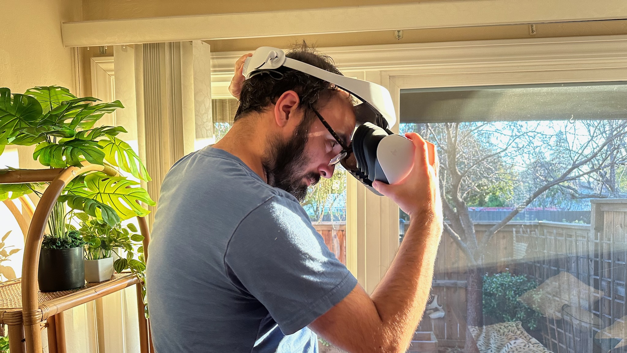 The author putting on the Sony PS VR2 while wearing glasses.