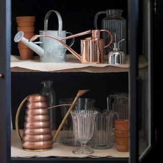 utility room with cupboards having watering can