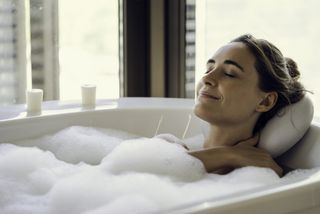 A woman relaxing in a warm bubble bath.