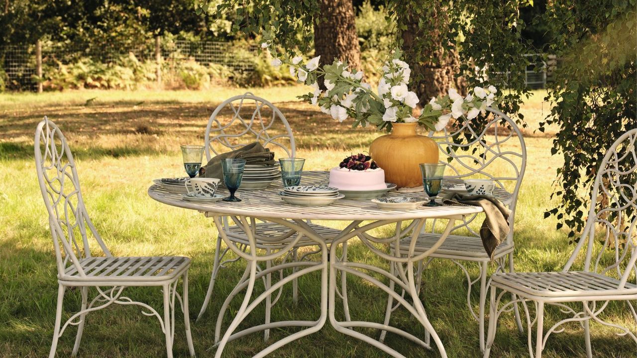 A set of elegant metal garden furniture beneath a tree