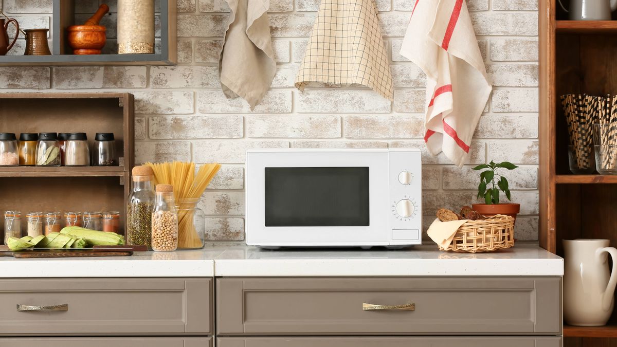 A modern looking microwave on a counter top in a modern kitchen