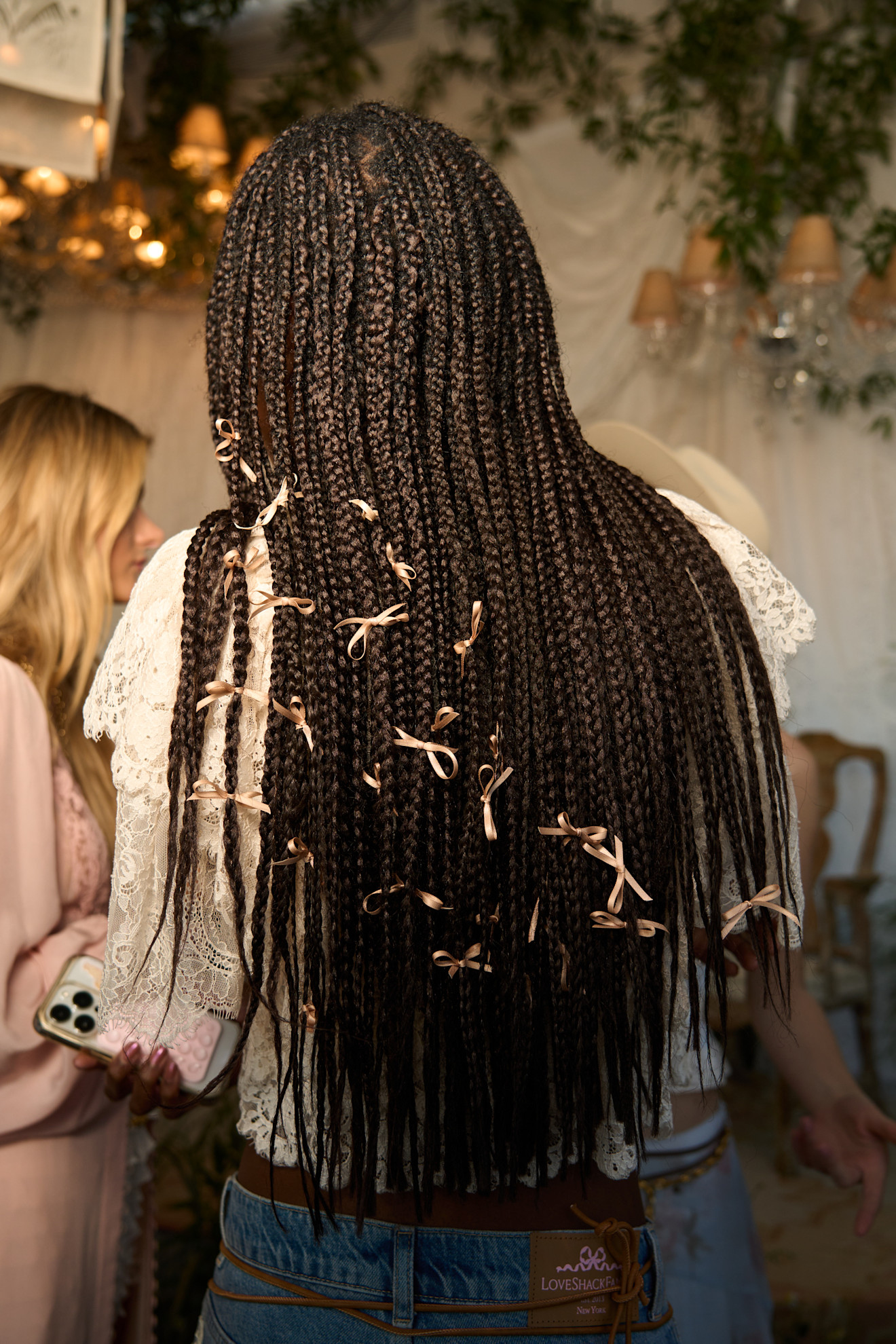 person with box braids styled with mini gold hair bow accessories