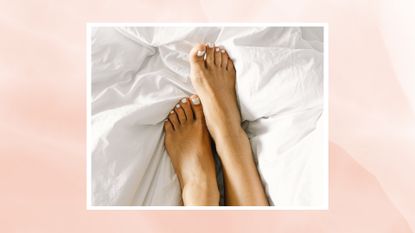 A close up of a woman&#039;s feet with a white pedicure on a white bed in the bedroom/ in a pastel pink template