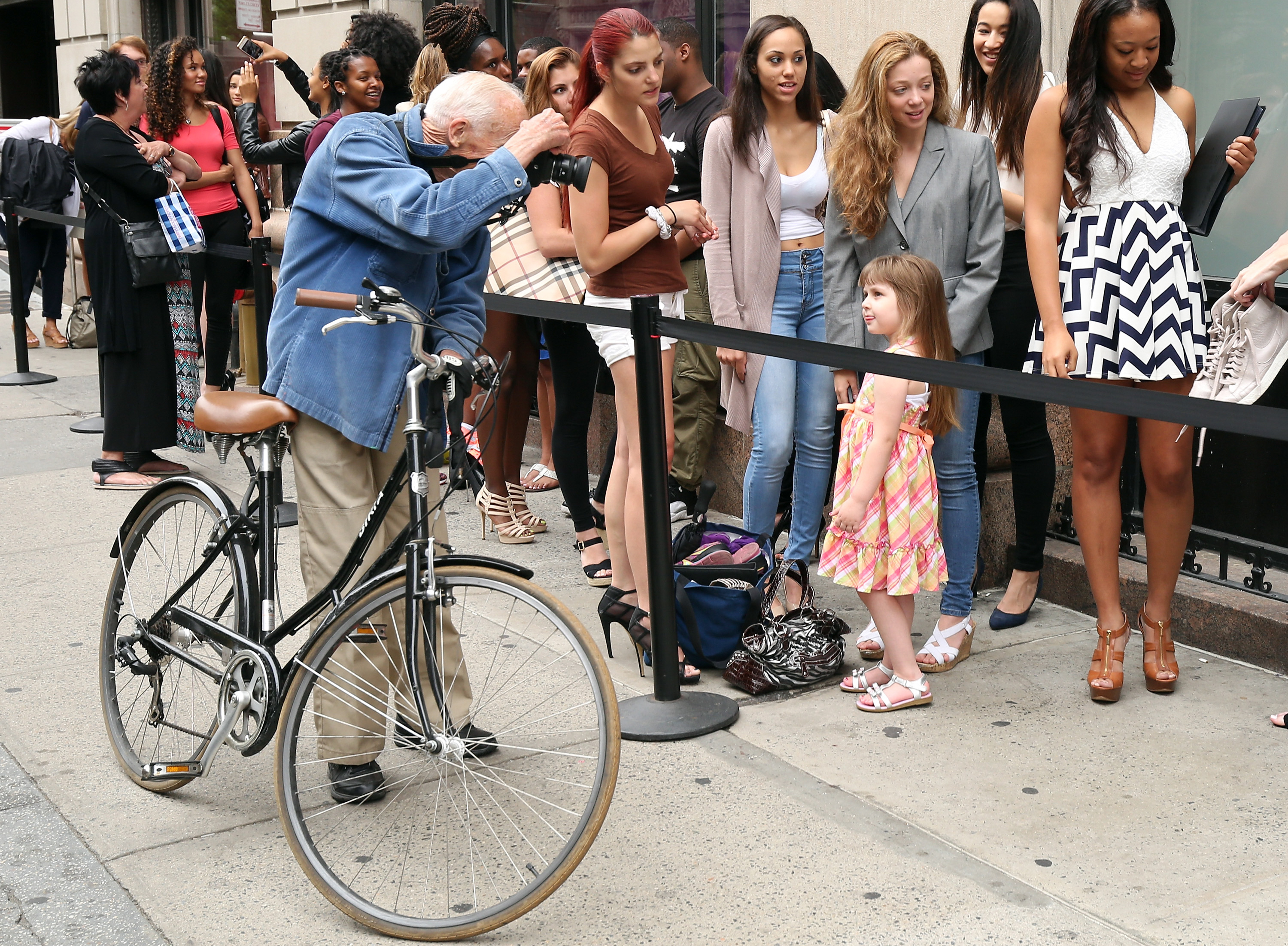 Photographer Bill Cunningham (L) photographs model contestants outside the European Wax Center and Wilhelmina Summer Goddess Model Search New York Open Call at Wilhelmina Models on June 27, 2015 in New York City. (Photo by Cindy Ord/Getty Images for European Wax Centers)
