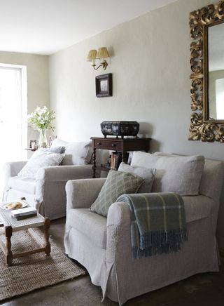cottage living room with two white armchairs and vintage decorative box on display