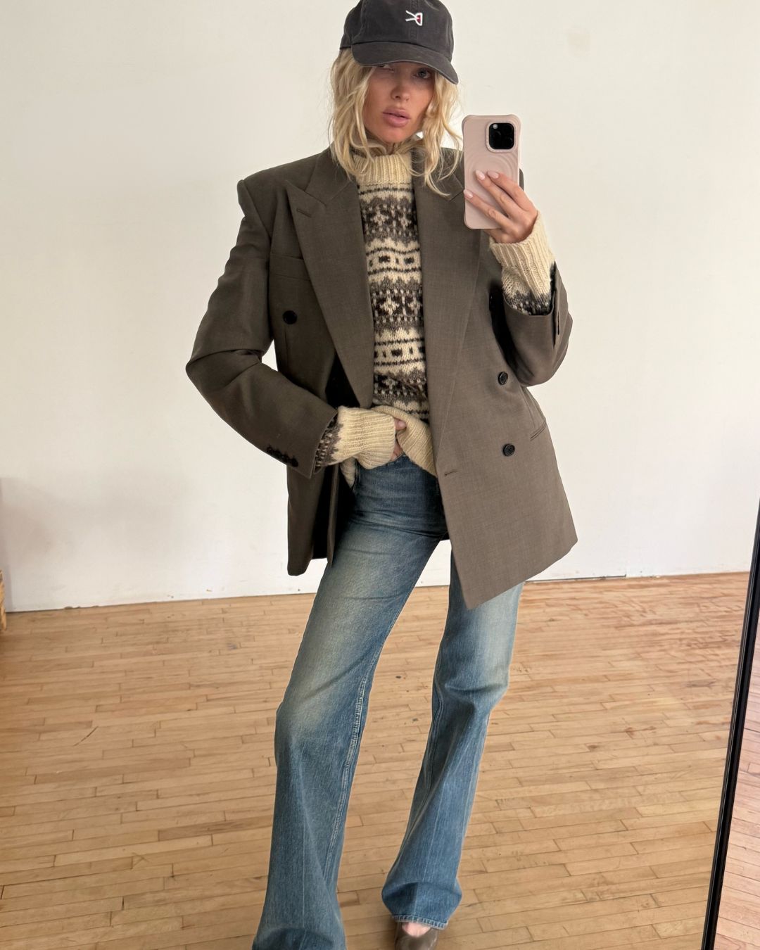 Elsa Hosk takes a mirror selfie wearing blue jeans with a mole colour blazer and matching heels.