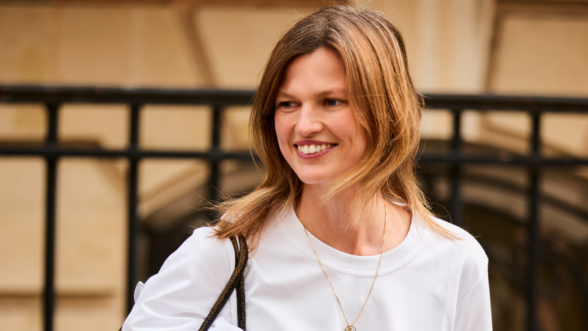A smiling woman wears a basic white T-shirt. 