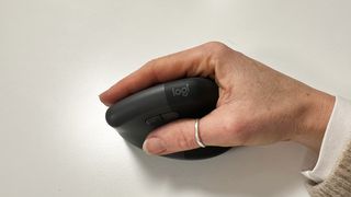 Hand wrapped around a Logitech Lift vertical mouse