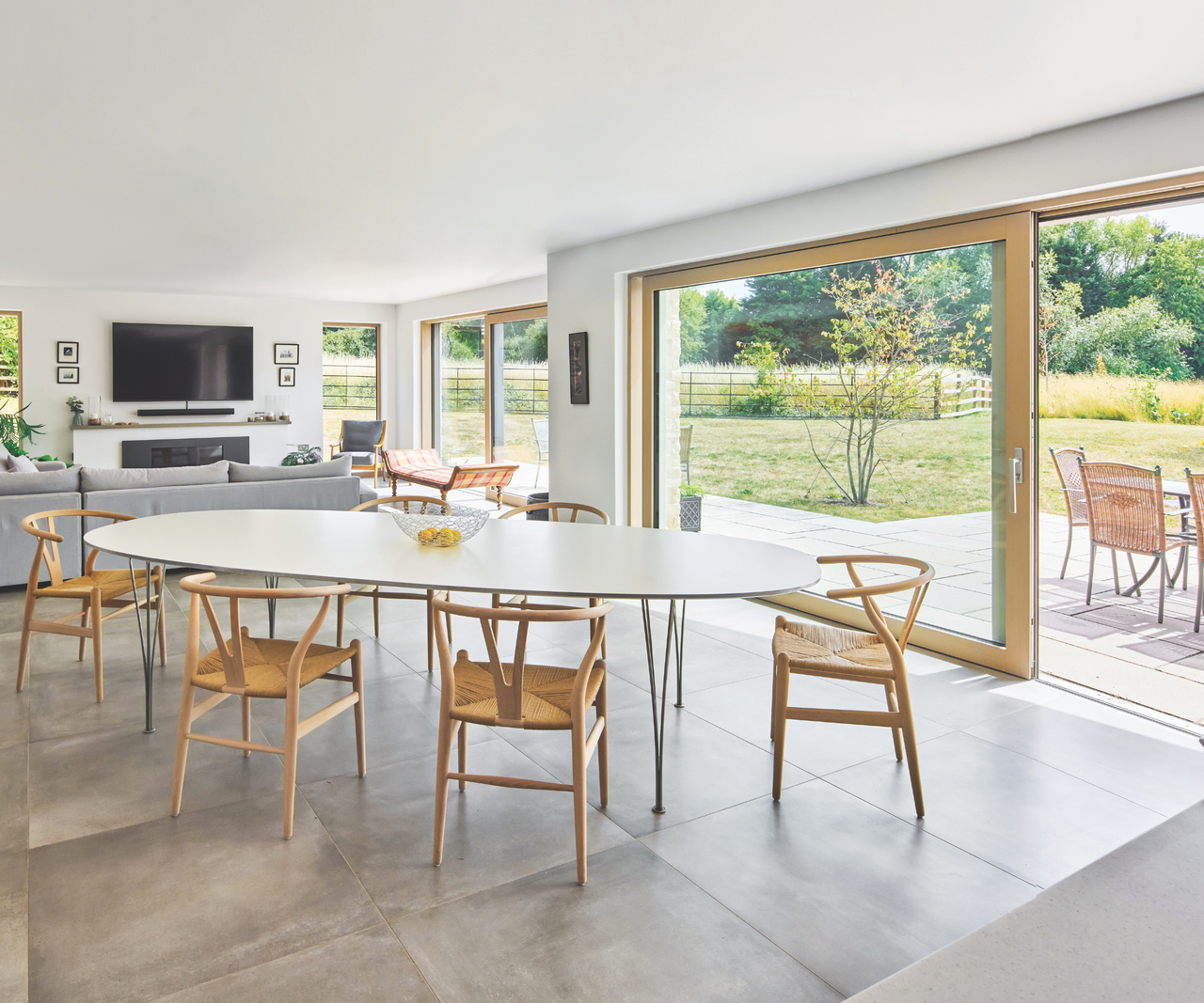 Open plan dining room living room with sliding doors opening out onto the patio and garden area