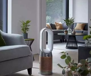 Dyson air purifier beside a sofa in a living room.
