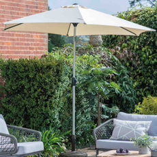 H&M Vazzano Parasol on a patio. here are two grey garden chairs sheltered underneath.