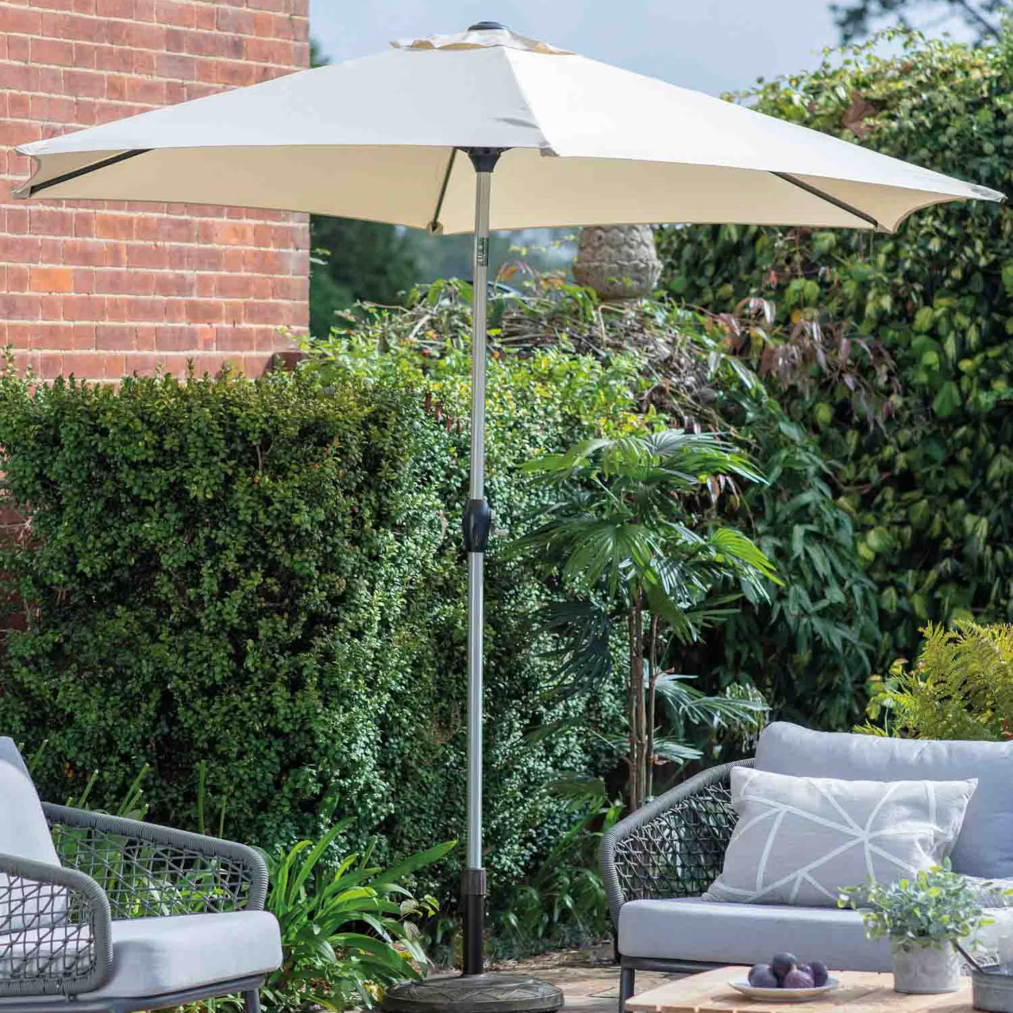 H&amp;M Vazzano Parasol on a patio. here are two grey  garden chairs sheltered underneath.