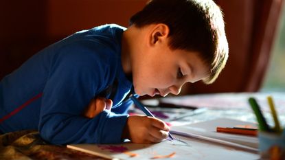 Young boy drawing at a table