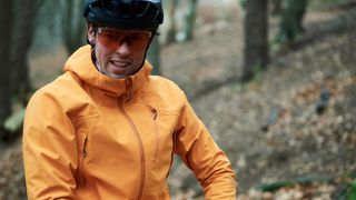 Head and shoulders shot of man in waterproof jacket and mountain bike helmet