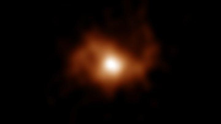 The blurry image of BRI 1335-0417, the oldest spiral galaxy in the universe, captured using radio emissions from carbon ions within the distant galaxy.