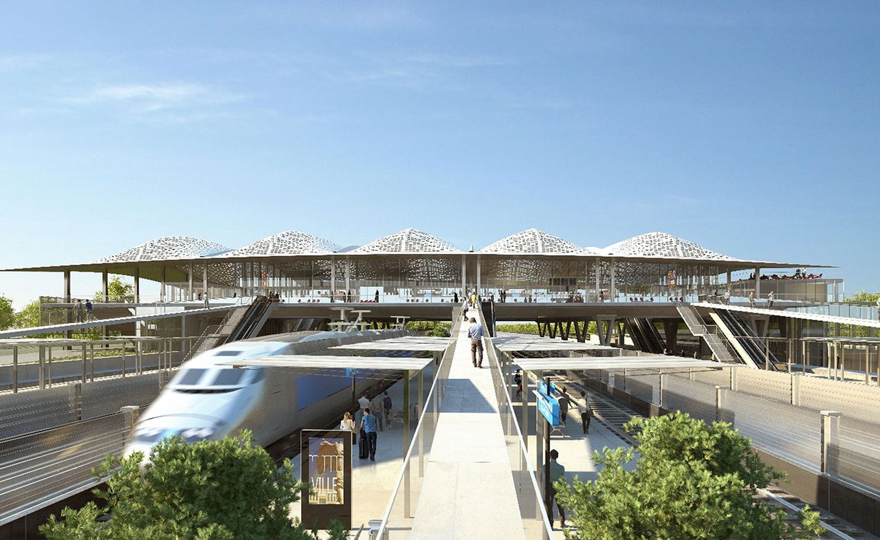 Train station featuring long, white walkways and a five-peaked roof with a netting design