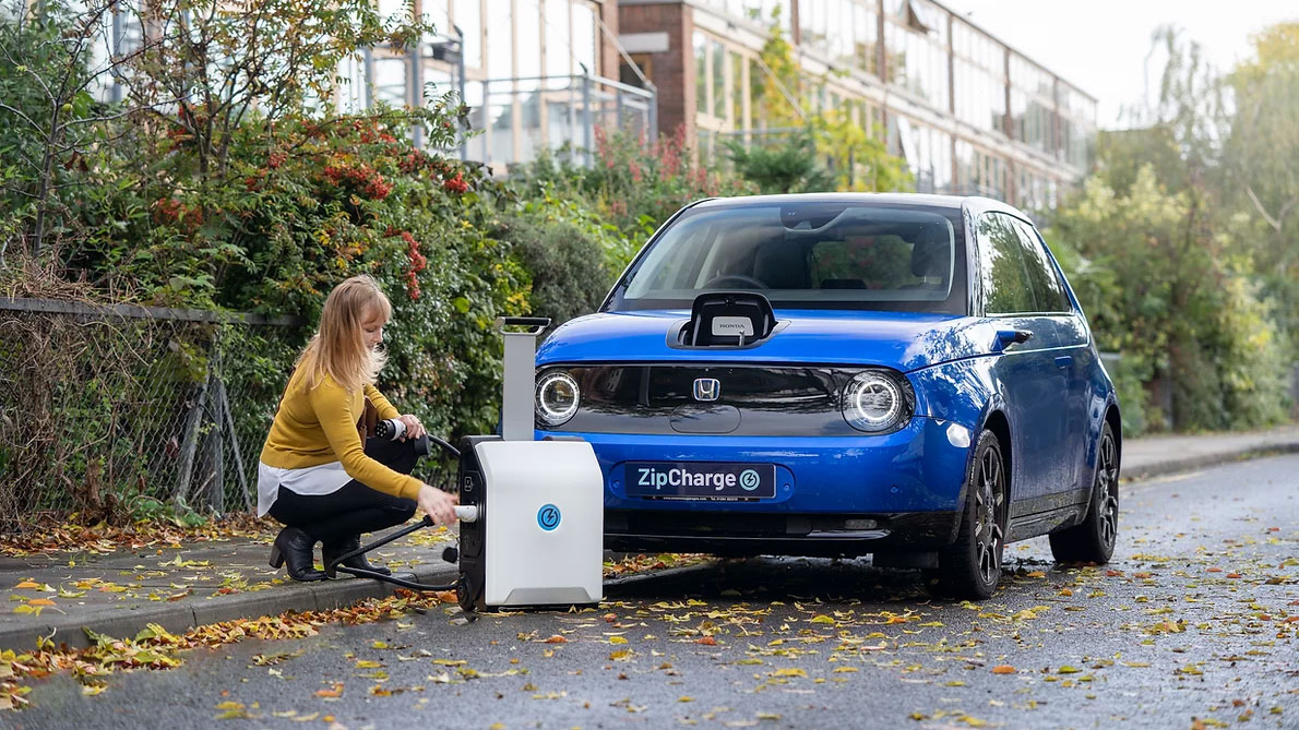 Woman plugging portable charger into an EV