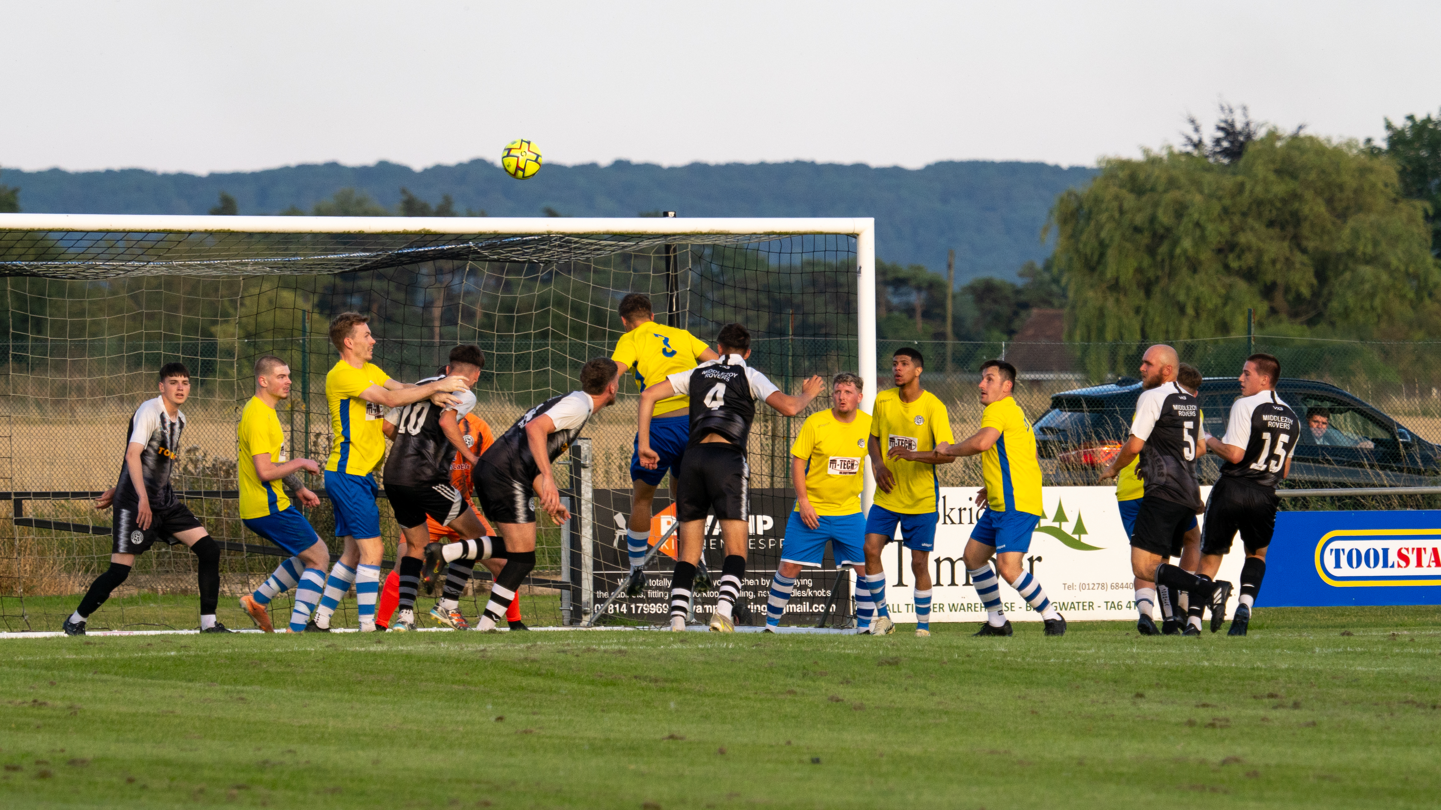 footballers playing football in front of a goal