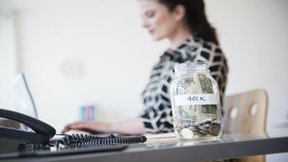 401k money jar on the desk of a businesswoman.