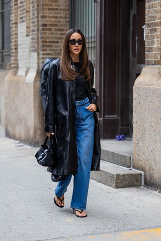 A woman at New York Fashion Week in jeans and a trench coat