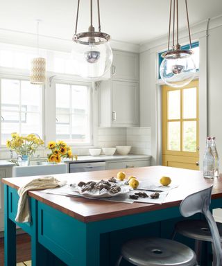 Neutral kitchen cabinet pared with a teal kitchen island