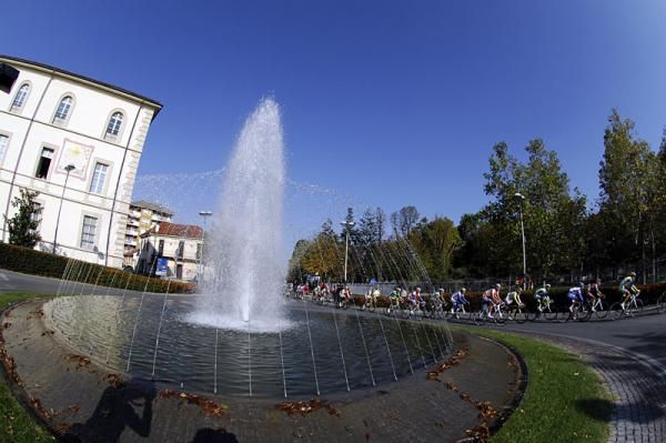 The peloton passes a fountain during the Giro del Piemonte.