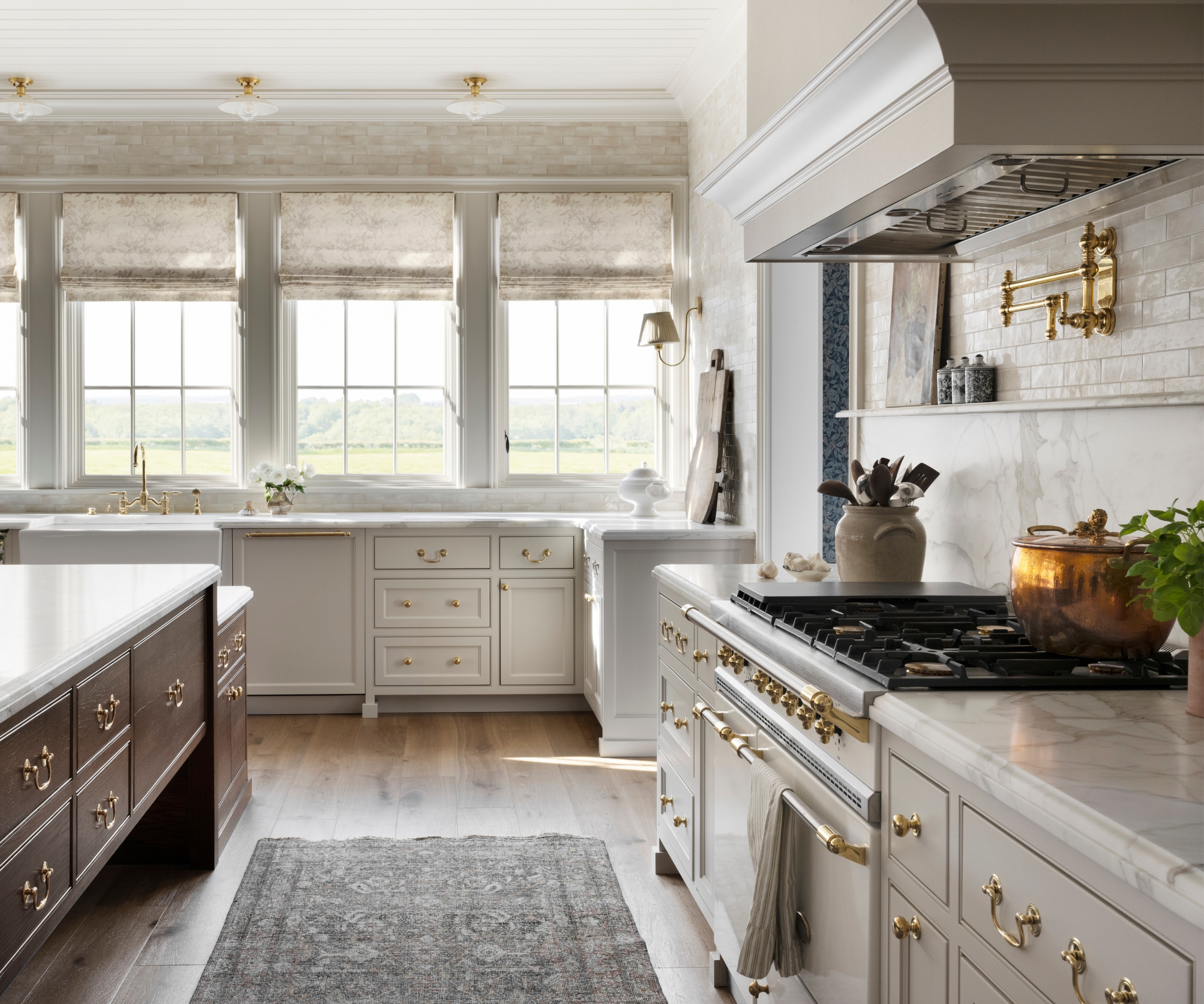 A light kitchen with warm white cabinets and marble countertops