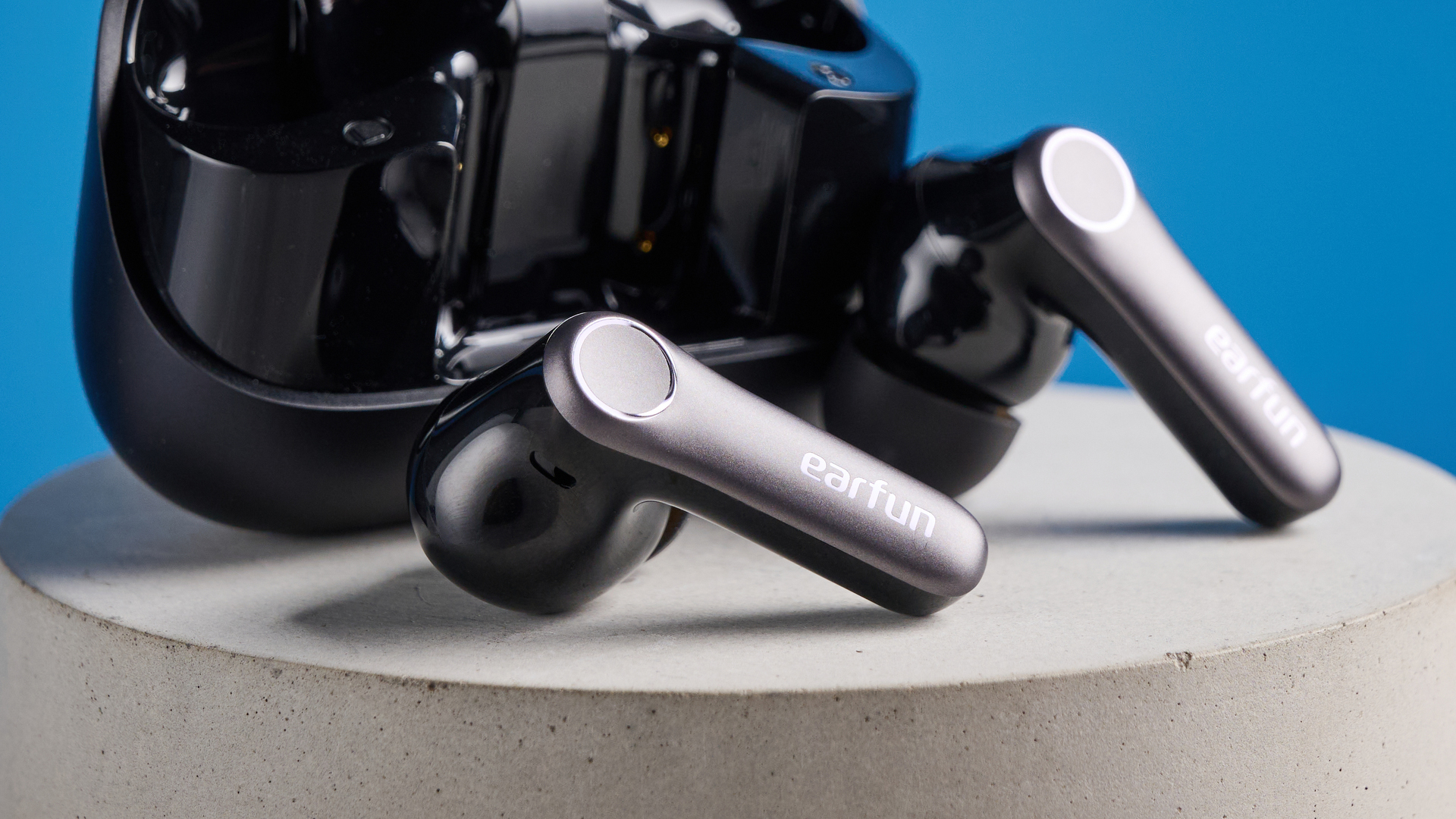 the earfun air pro 4+ earbuds in black showing the ear tips, charging case, and being worn