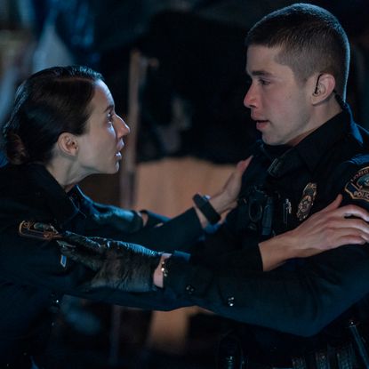 A female cop (Troian Bellisario) holds a male cop's (Brandon Larracuente) arms, in 'On Call.'