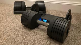 JAXJOX adjustable dumbbell next to docking station