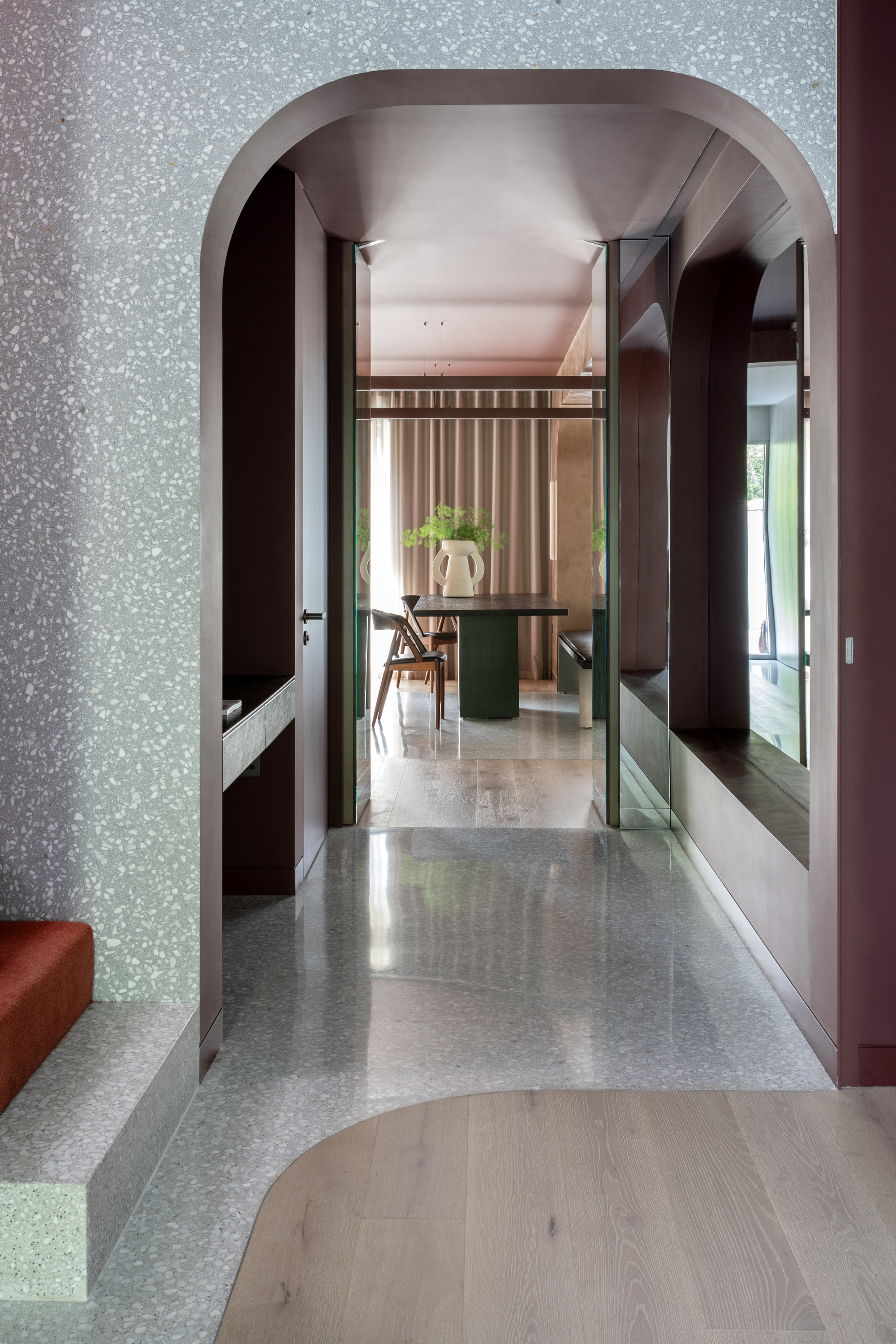 A curved speckled stone archway in a hallway