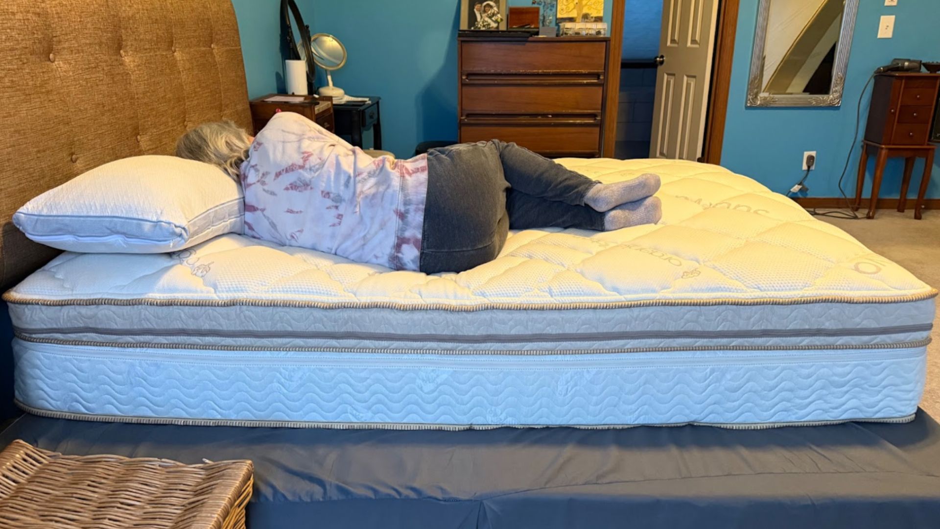 A woman laying on her side on white pillow on Saatva Solaire mattress