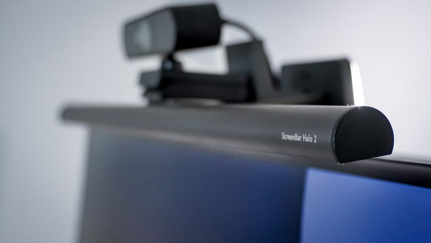 An angled view of the BenQ ScreenBar Halo 2 on top of a monitor with a webcam installed above it